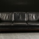 Tre-personers sofa af sort læder.