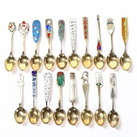 A. Michelsen. Collection of Christmas spoons from 1943-1960, partly gilded silver & sterling silver w/ enamel. (18)