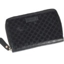 Gucci: A zipped wallet of black microguccissima embossed leather. Model 449423.