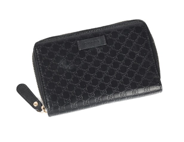 Gucci: A zipped wallet of black microguccissima embossed leather. Model 449423.