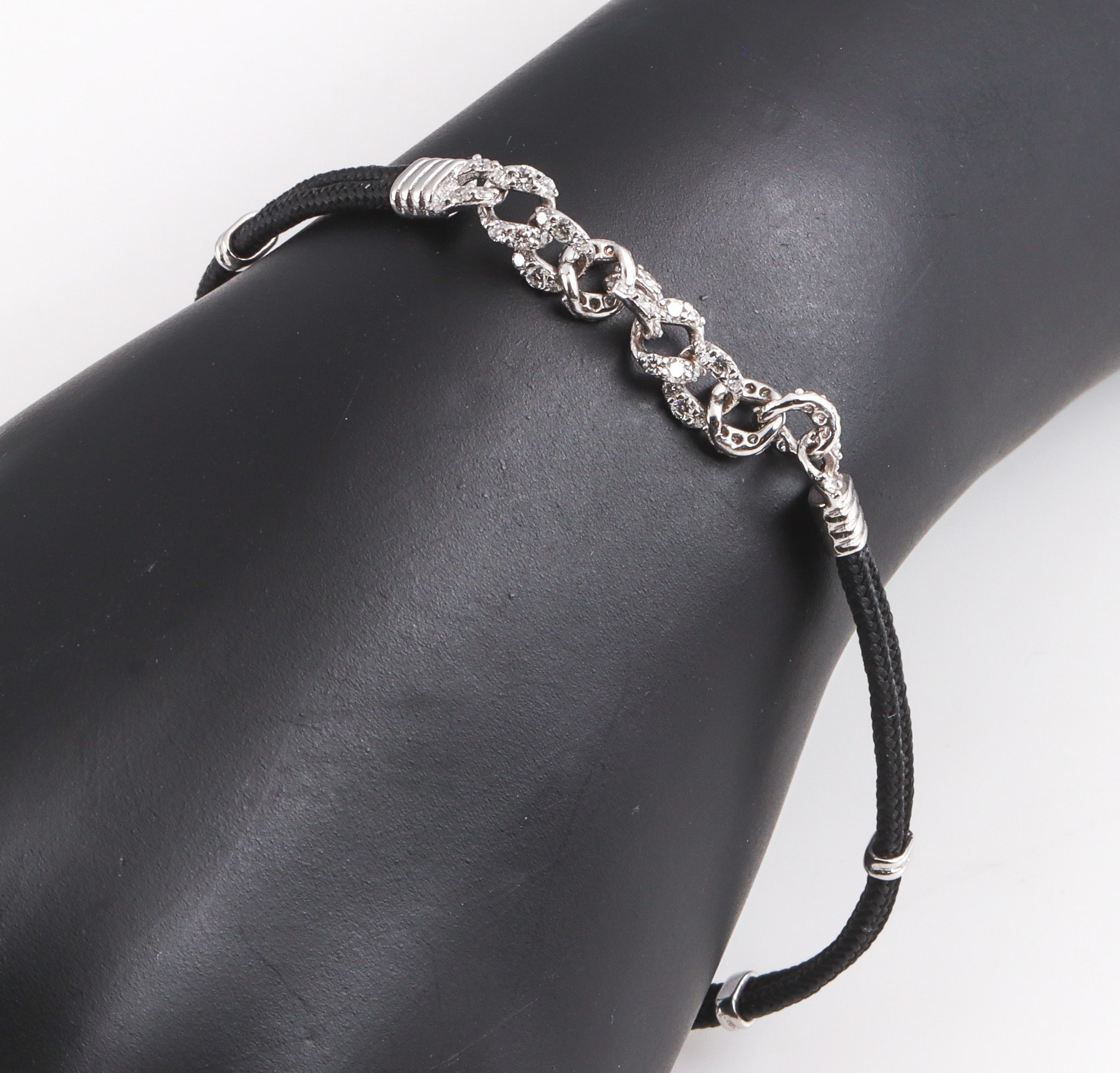 Modern diamond bracelet in 18 kt. white gold and black silk cord, total approx. 0.76 ct.