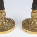 A pair of Empire style candlesticks, a silver candlestick, a glass candlestick (4)