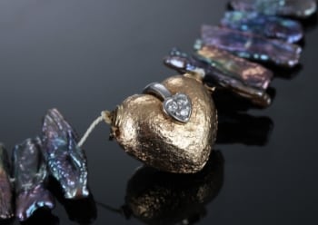 Hjertelås i 18 kt guld med tre diamanter, halskæde i perlemor.