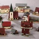 Flyttekasse med Faller huse samt tilbehør til modeljernbane