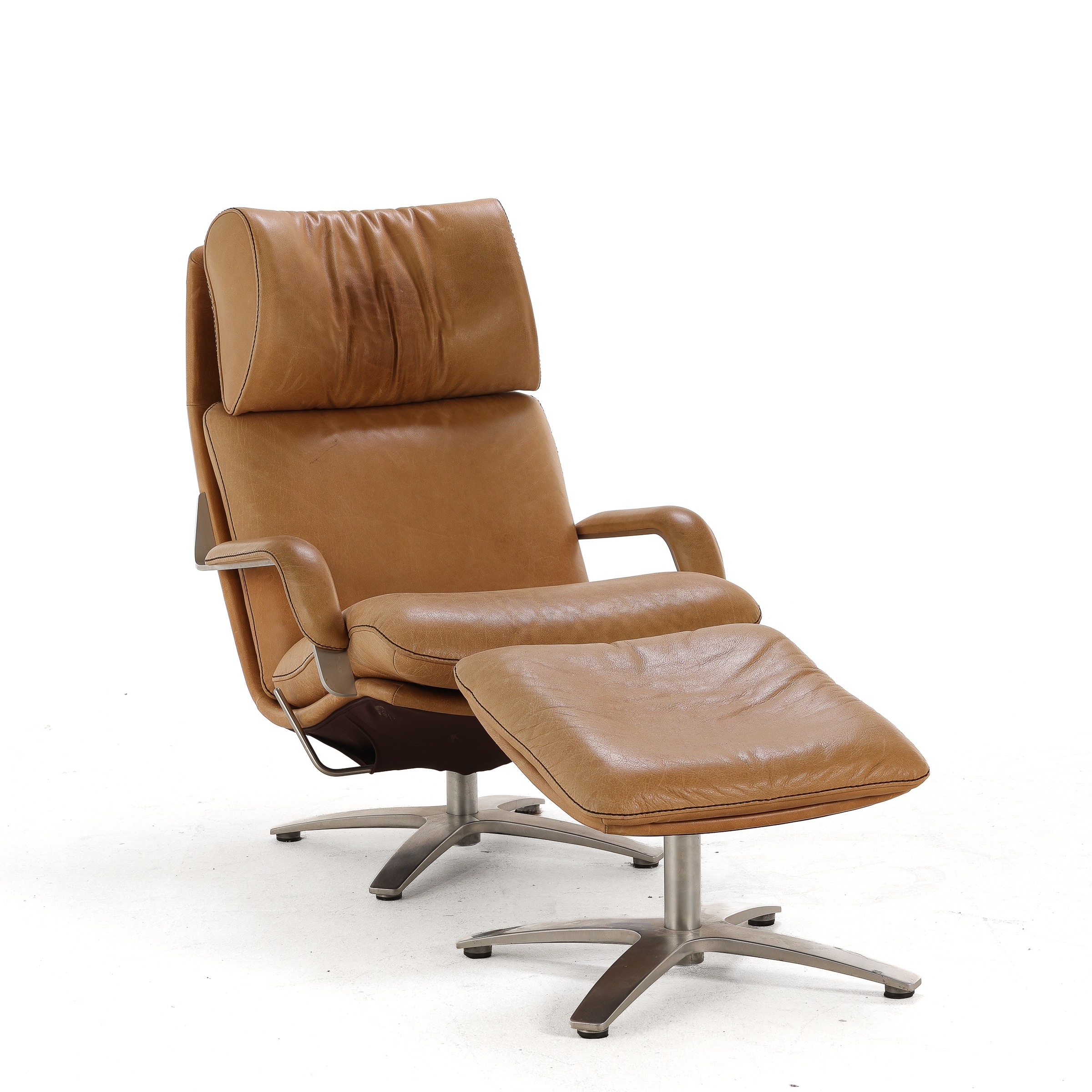 Danish furniture manufacturer circa 2020: Lounge chair with slightly tilted pouf.