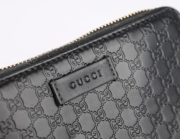 Gucci: A zipped wallet of black microguccissima embossed leather. Model 449423.