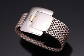 A bracelet in the shape of a belt of sterling silver and 18k gold.