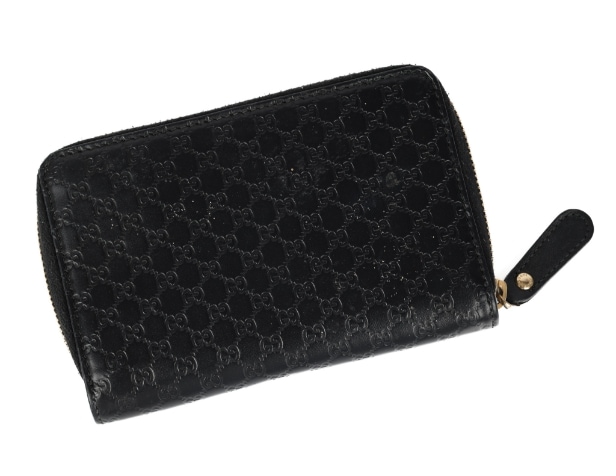 Gucci: A zipped wallet of black microguccissima embossed leather. Model 449423.