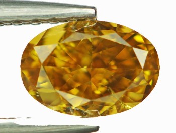 Uindfattet fancy gul orange, ovalsleben diamant på 0.77 ct.