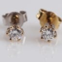 A pair of 14k gold solitaire earrings, 0.20 ct. (2)