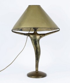 Bordlampe af bronze i.f.a. stående figur holdende skærm af hammerslået messing. Ant. mellemeuropa ca. 1940-50.