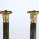 A pair of Empire style candlesticks, a silver candlestick, a glass candlestick (4)
