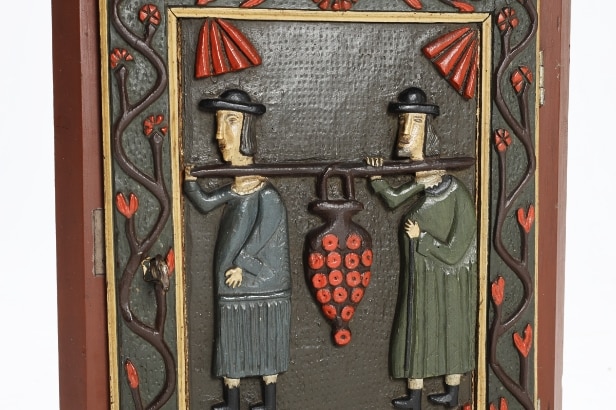 Small corner cabinet with carved figures on the door