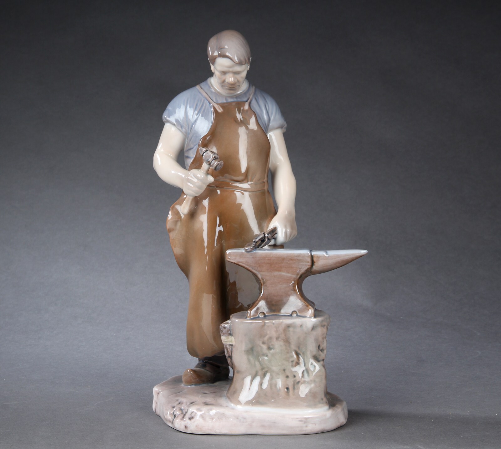 Axel Locher for Bing & Grøndahl. Smed ved ambolt, figur i porcelæn ...