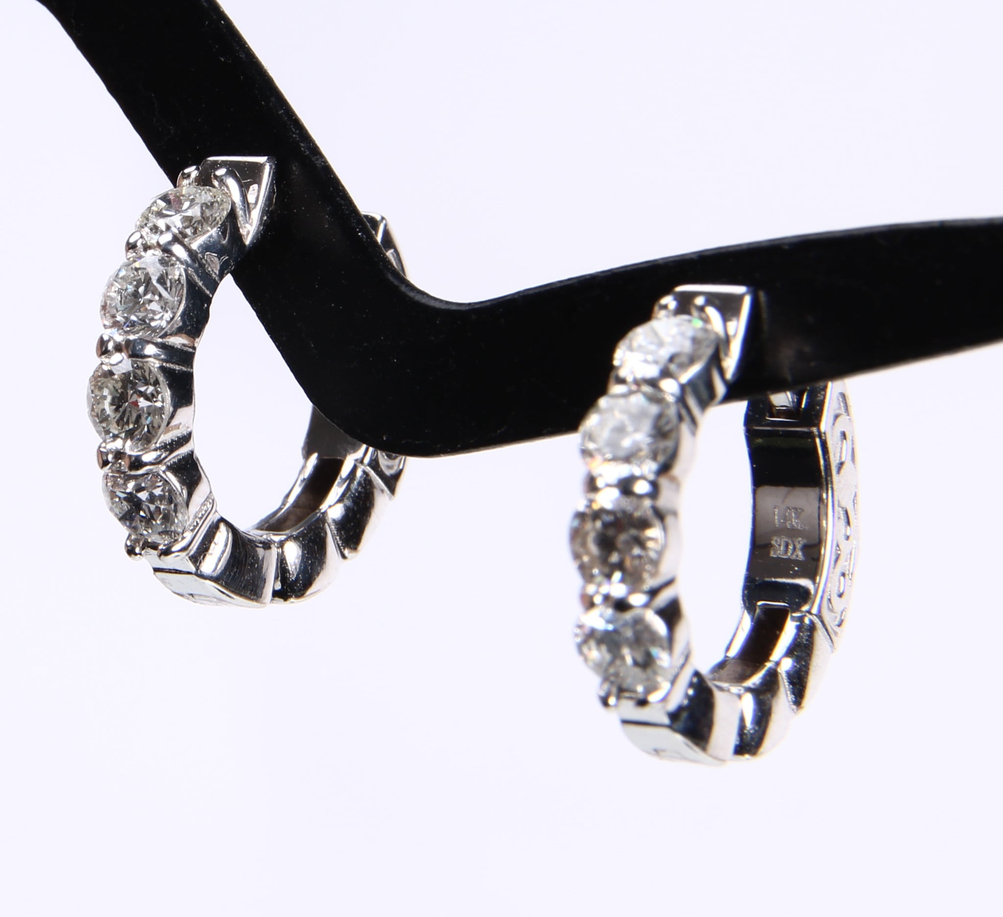 A pair of huggies diamond earrings in 14 kt. white gold, totaling 1.00 ct. (2)