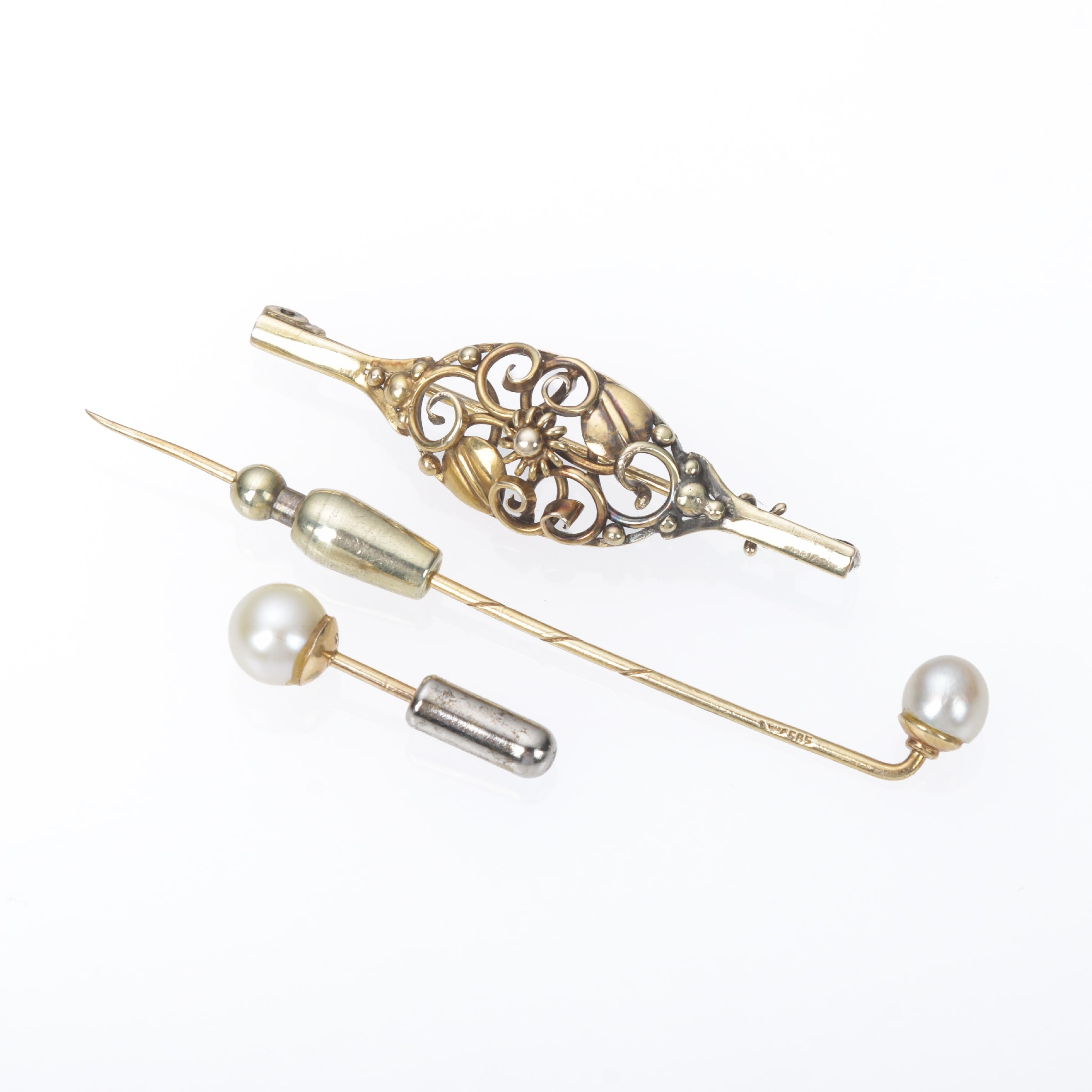 An Art Nouveau brooch and two pearl lapel pins of 14k gold. (3)